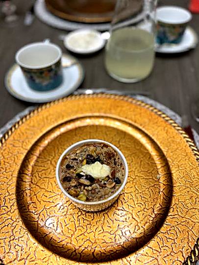 A small dish of Om Ali, pastry baked in sweetened milk with nuts and raisins.
